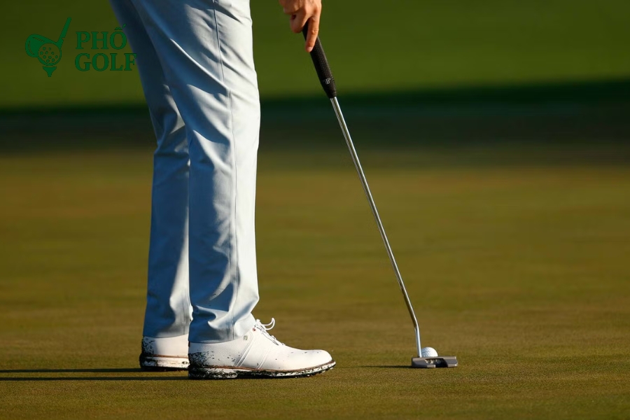 Tốc độ green là gì, bí quyết chinh phục mọi sân golf? Golfer thực hiện cú putt trên green chậm, backswing dài và follow-through đầy đủ, minh họa kỹ thuật “hit through the ball”